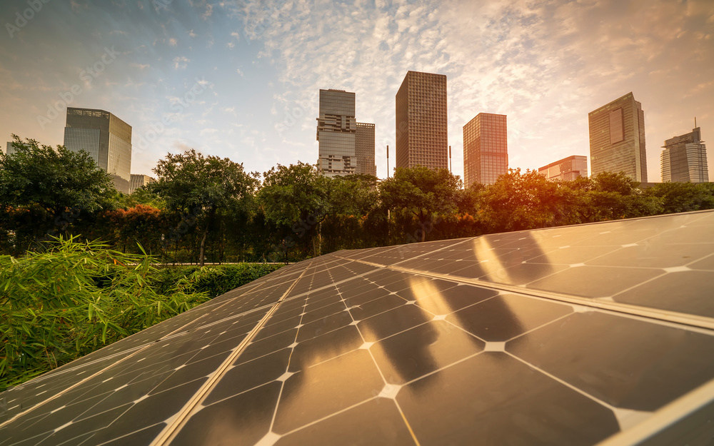 Solar panels in an urban setting with skyscrapers in the background, showcasing sustainable energy in cities